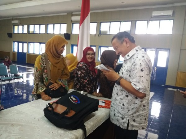 H.IIm Sarbini Bendahara Koprasi KGS Soreang sedang membagikan SHU kepada Anggota di Gedung Korpri, Kabupaten Bandung, Sabtu (29 / 2 / 2020