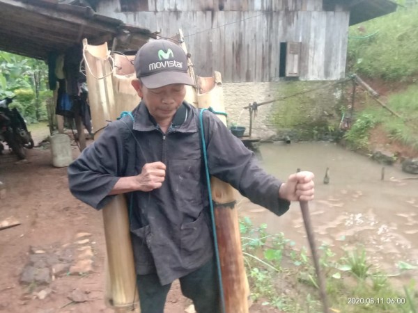 Sukandi setia membawa lodong, pergi ke kebun mengambil air lahang (bahan baku gula) dari pohon aren.