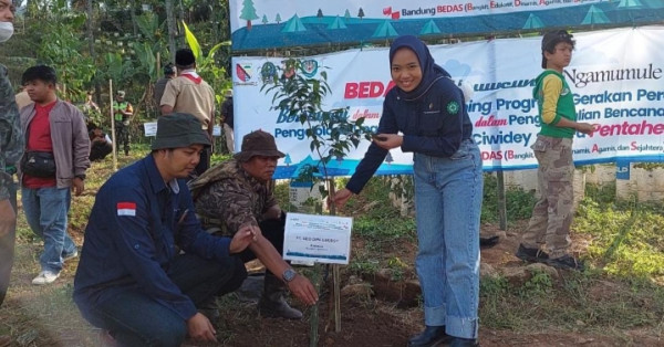 Divisi HSE GeoDipa Agung Maulana didampingi,  Annisa Nadhilah saat melakukan penanaman pohon di Kp. Citiis Desa Alamendah Kecamatan Rancabali   Sabtu (24/9/2022). Photo-Lee.